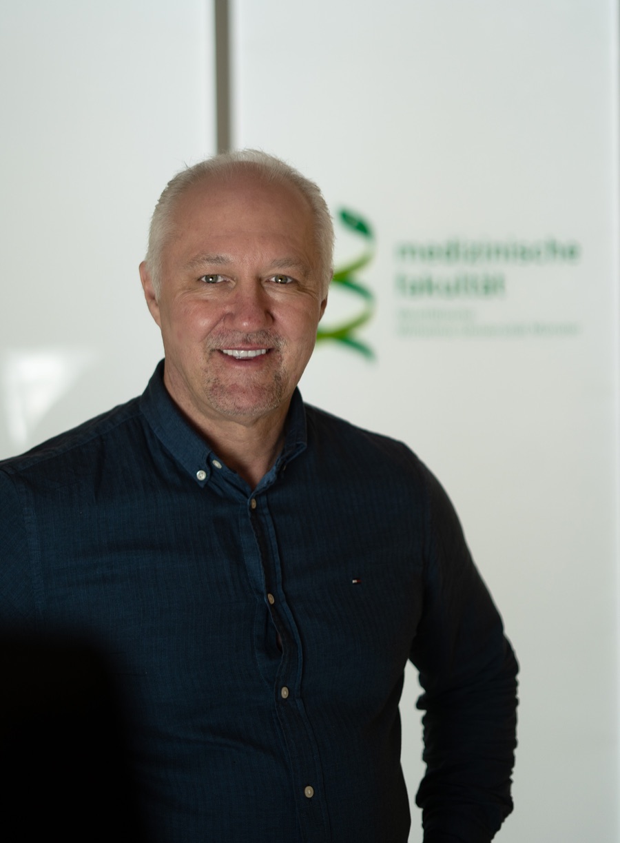 Dr. André C. Dennes – freundliches Porträt vor der Medizinischen Fakultät Münster